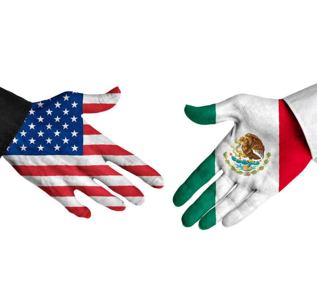 Diplomatic handshake between leaders from the United States and Mexico with flag-painted hands.